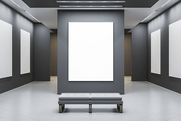 istock Modern art gallery interior with blank white posters on dark walls and bench in foreground for design or branding mockup display template scene. 3D Rendering 2214346177