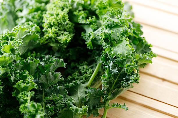 istock Fresh green Kale leaf salad vegetable on wooden background. 2214346385