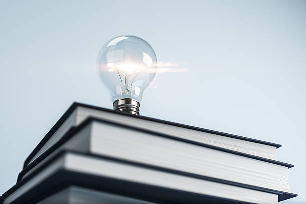 istock Lightbulb glowing on stacked books symbolizing learning, growth, and creative ideas in education and innovation concept on light background. 3D Rendering 2214346537