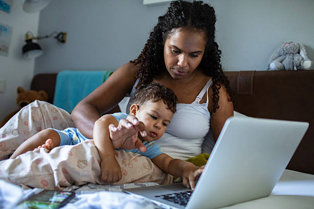 istock Young mother using a laptop with her son at home 2214347476
