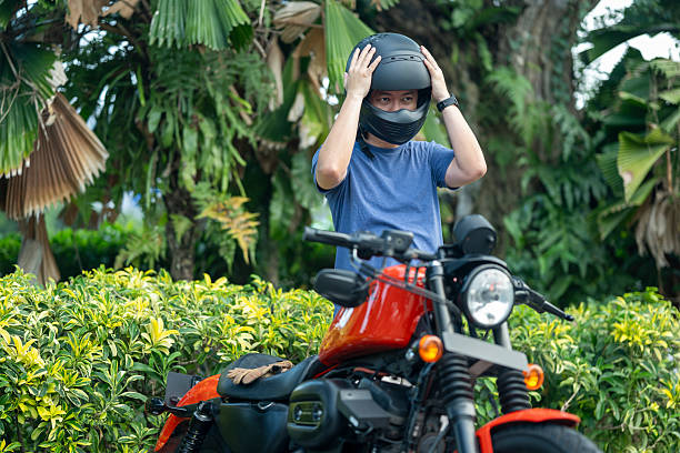 Asian Chinese Motorcylist putting on helmet