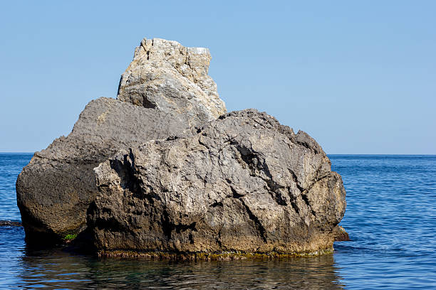 istock Large stone in calm water 2214353236