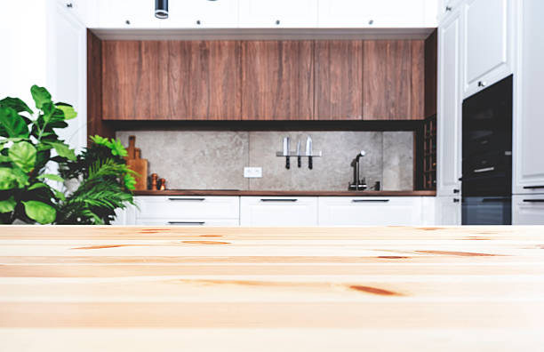 istock Blurred white and wood kitchen interior with wooden table, modern classic, with induction hob, black sink and furniture fittings, wine bottle holder, knife magnet, kitchen utensils and cookware. Real photo 2214353778