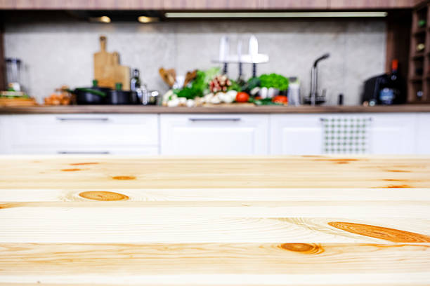 istock Blurred white and wood kitchen interior with wooden table, modern classic, with induction hob, black sink and furniture fittings, wine bottle holder, knife magnet, kitchen utensils and cookware. Real photo 2214353791
