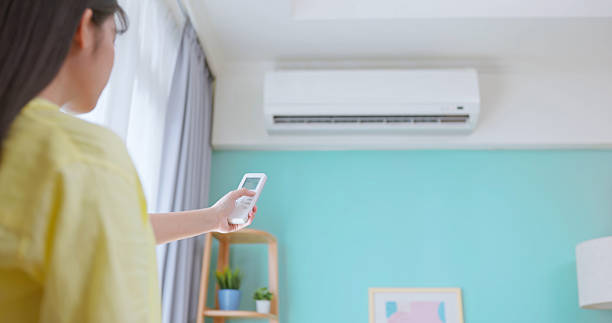 istock woman turn on air conditioner 2214359089