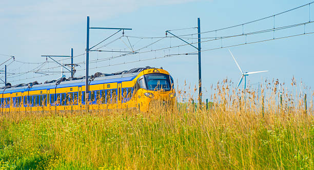 istock Electric train riding on a railroad track in nature in sunlight in springtime 2214362345