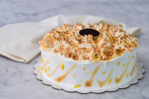 istock Toasted Lemon Meringue Layer Cake featuring moist cake layers with a tangy lemon filling with napkin isolated on grey background side view of dessert 2214365542