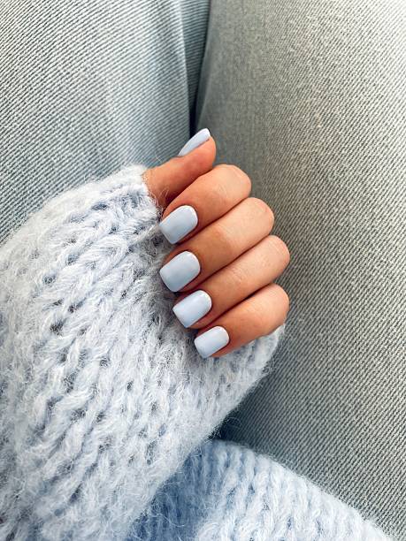 istock Woman's hand with light blue nail polish wearing a soft blue sweater 2214372898