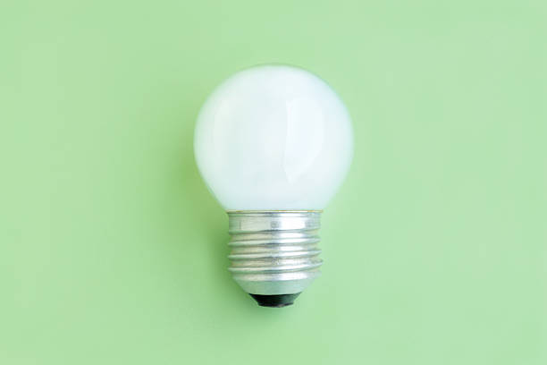istock Old light bulb on green background, White electric lamp 2214372907