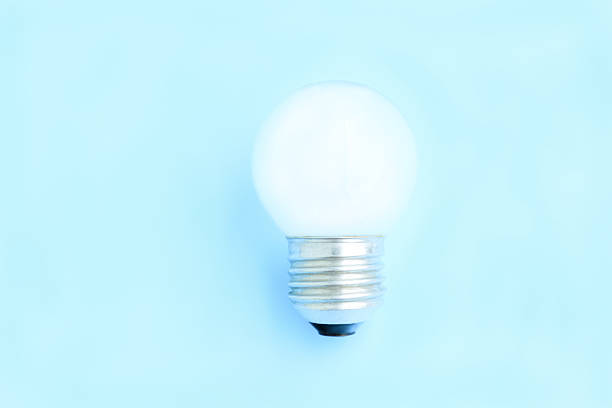 istock Old light bulb on blue background, White electric lamp 2214372941