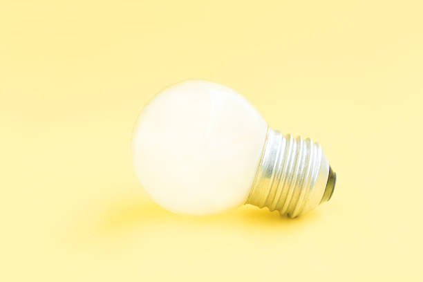 Old light bulb on yellow background, White electric lamp