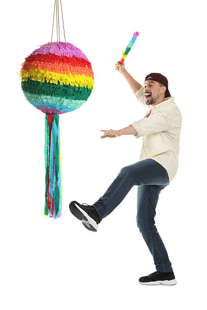 istock Emotional man hitting colorful pinata with stick on white background 2214376606