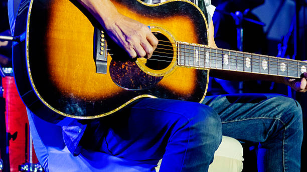 istock Sitting guitarist playing on stage 2214377006