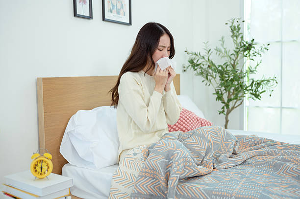 istock Young asian woman feeling sick in her bedroom 2214377264