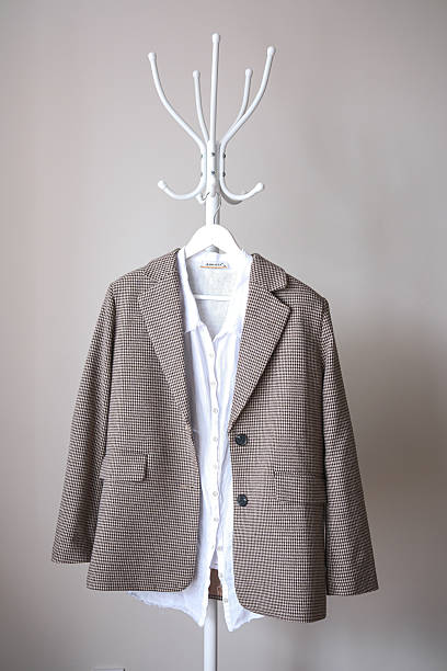 A modern blazer stylishly paired with a crisp white shirt displayed beautifully on an elegant coat rack