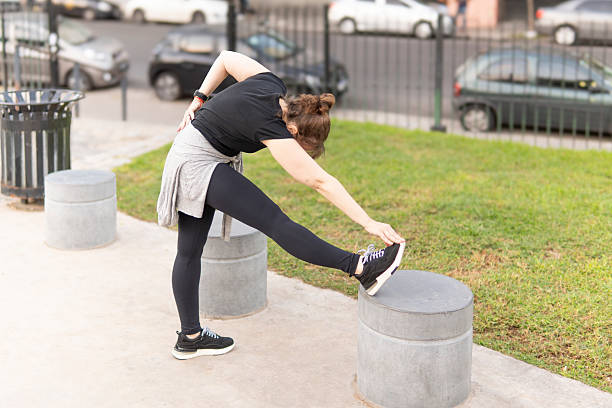 istock Getting ready to move: Woman's outdoor pre-exercise stretch 2214390070