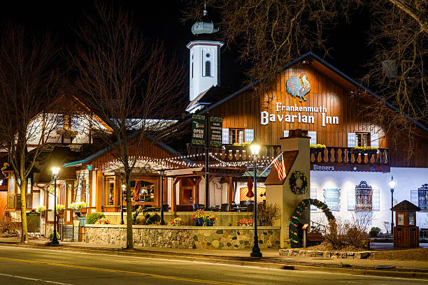 Frankenmuth, MI, USA - 04-22-2025: Photo of Frankenmuth Michigan city center showing Bavarian-style shops and attractions illuminated at night with quiet empty streets.