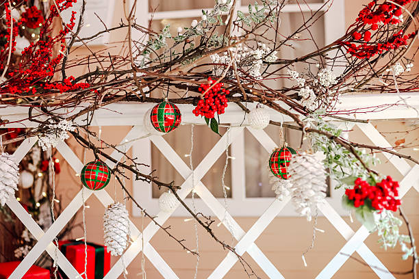 Festive decor adorns a white railing with red berries and ornaments creating a cheerful atmosphere for winter celebrations.