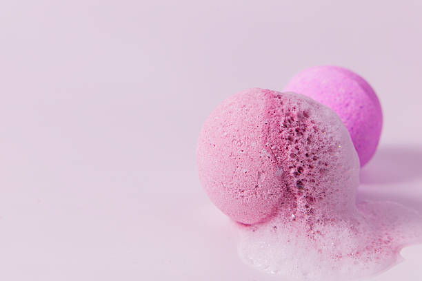 istock Colorful bath bombs fizzing on a light pink surface in a relaxing atmosphere 2214396280