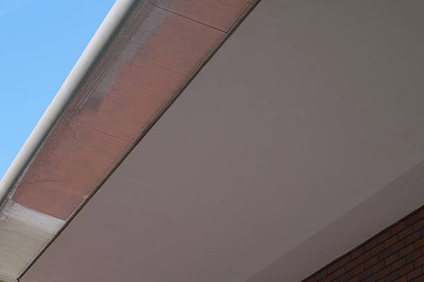 istock Rain gutter collecting water on building roof against blue sky 2214402733