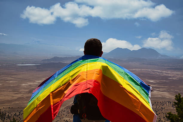 istock Hiker showing rainbow flag on mountain top celebrating lgbtq pride 2214403235