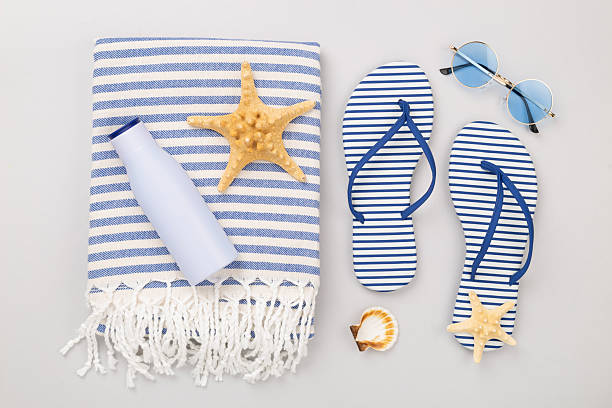 istock Beach towel with summer accessories on color background, top view 2214404145
