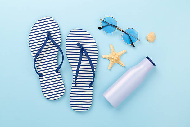 istock Striped blue flip flops with accessories on color background, top view 2214404154