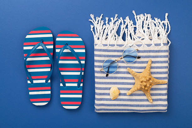 istock Beach towel with summer accessories on color background, top view 2214404155