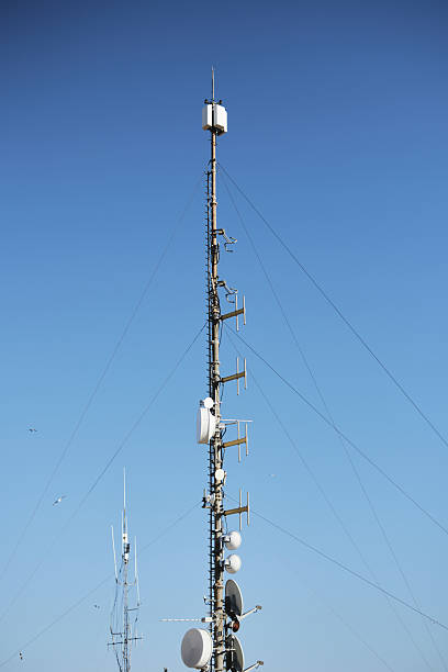 istock Tall communication tower against clear blue sky with antennas and dishes 2214405110