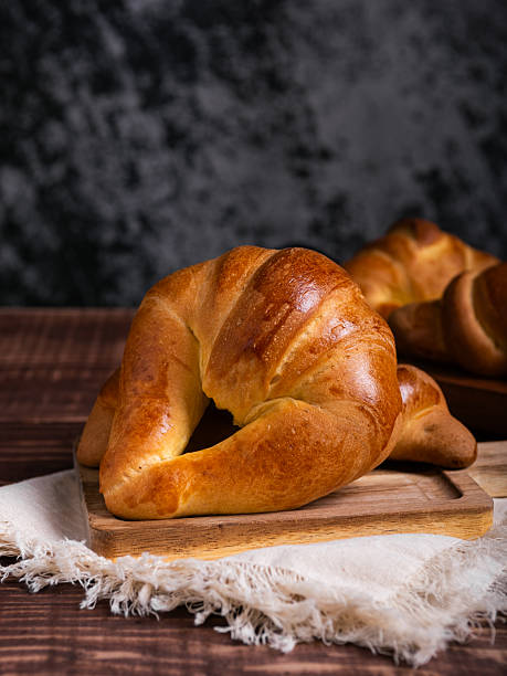 istock Golden Croissant on Rustic Wooden Board 2214407030