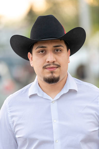 istock Hispanic man posing wearing a cowboy hat looking at camera 2214409746