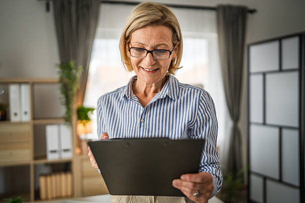 istock Mature woman watch tablet and drink coffee at office at work 2214411468