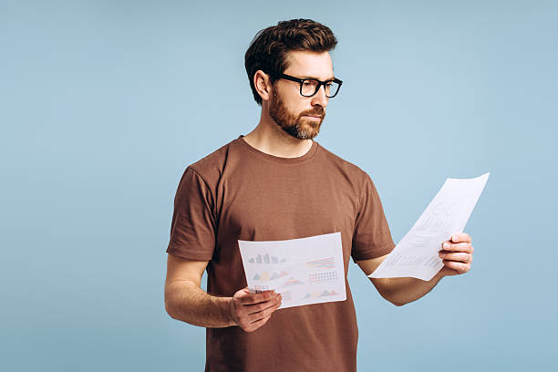istock Pensive businessman wearing eyeglasses analyzing financial charts and graphs 2214412721