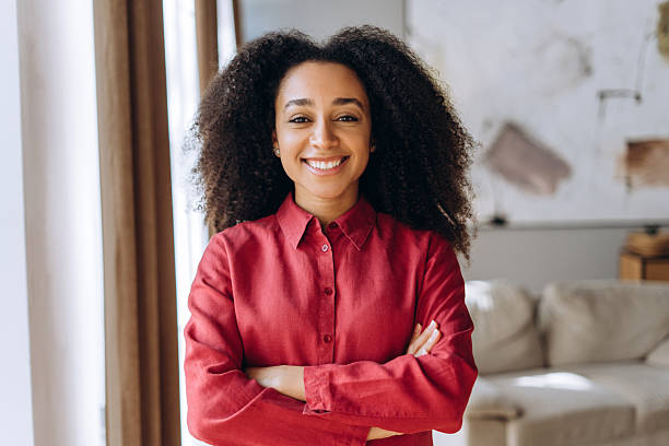 istock Confident young African American manager smiling with folded arms in modern office 2214414829