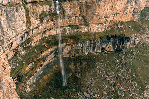 istock Majestic waterfall cascading down a rocky cliff in a serene landscape surrounded by nature. 2214416784