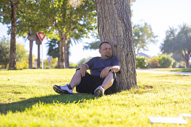 A hispanic man sitting and relaxing at the park