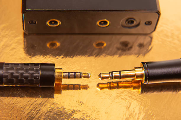 istock Two 3.5mm headphone jacks with gold-plated tips on a shiny gold background, perfect for showcasing audio technology and connectivity. 2214417992