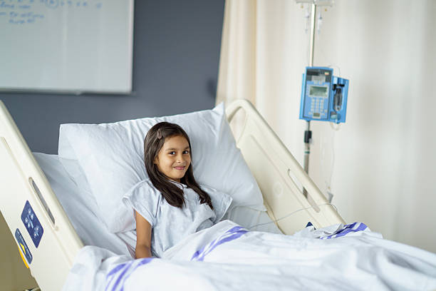 istock Young Girl Smiling While Resting in a Comfortable Hospital Bed 2214422289