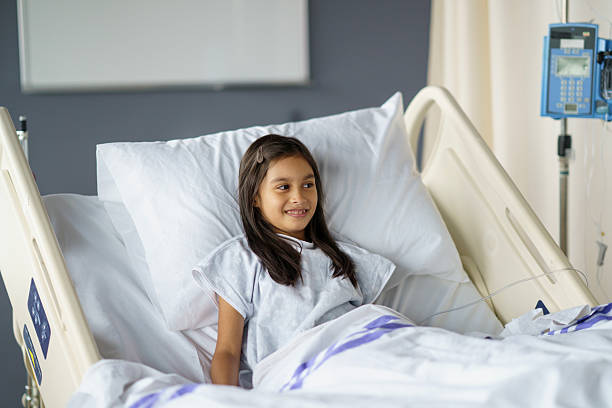 istock Young Girl Smiling While Resting in a Comfortable Hospital Bed 2214422298