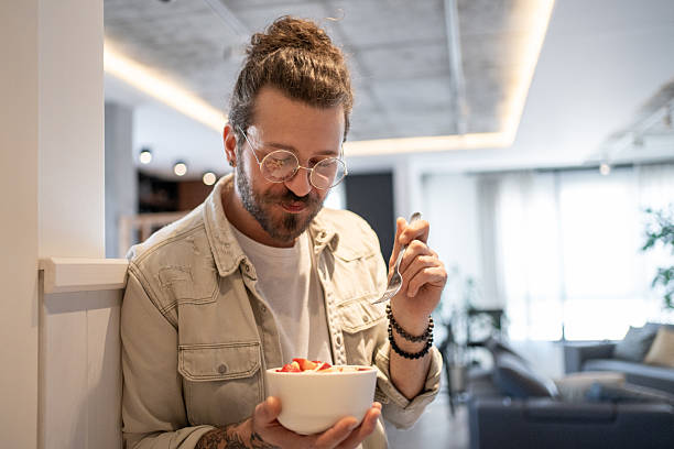 istock Young man enjoying a healthy breakfast at home 2214424100