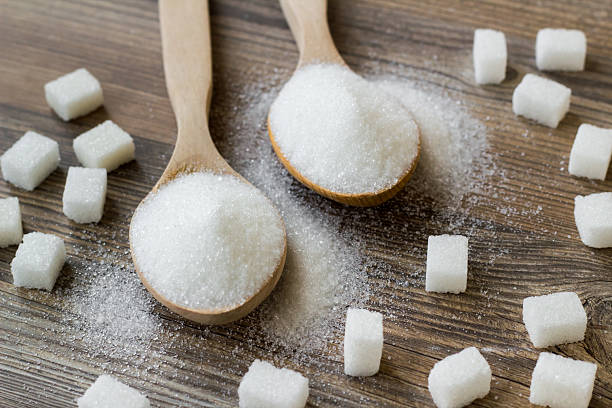 istock Granulated sugar in wooden spoons 2214426328