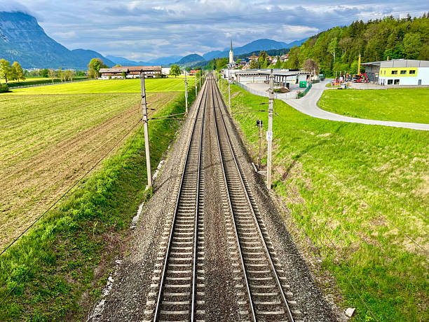 Railway Tracks in Scenic Austrian Countryside with Mountain View.