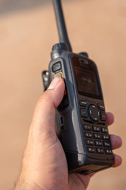 istock A radio operator is holding a rugged Walkie-Talkie. 2214443714
