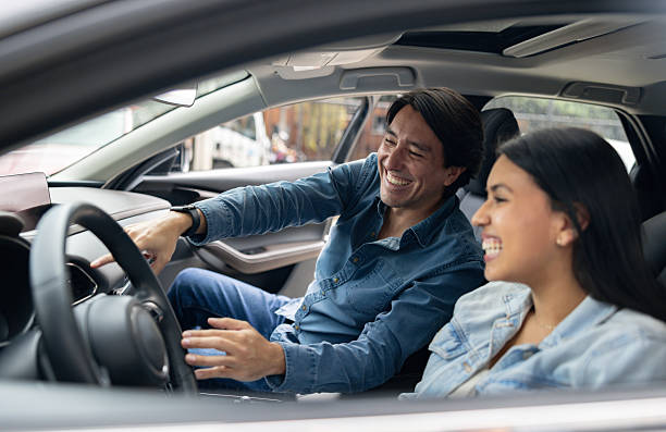 istock Happy father teaching his daughter to drive and smiling 2214444183