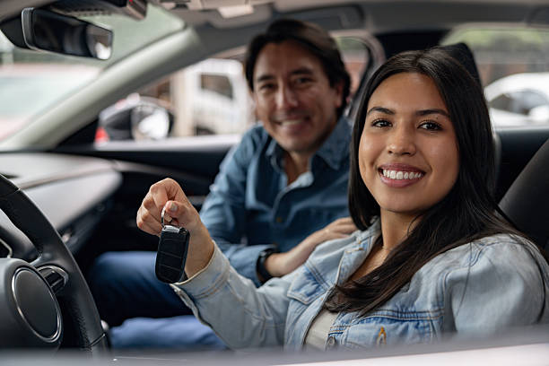 istock Father and daughter inside a car holding the keys and smiling 2214444196