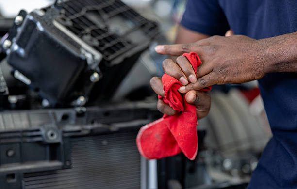 Close-up on a mechanic cleaning his hand with a cloth at a garage