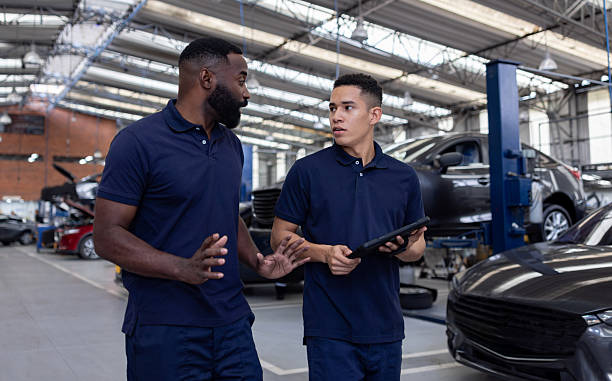 istock Mechanics talking while working at an auto repair shop 2214445663