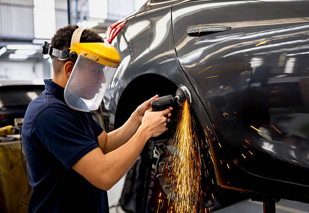 Mechanic grinding a car while working at an auto repair shop
