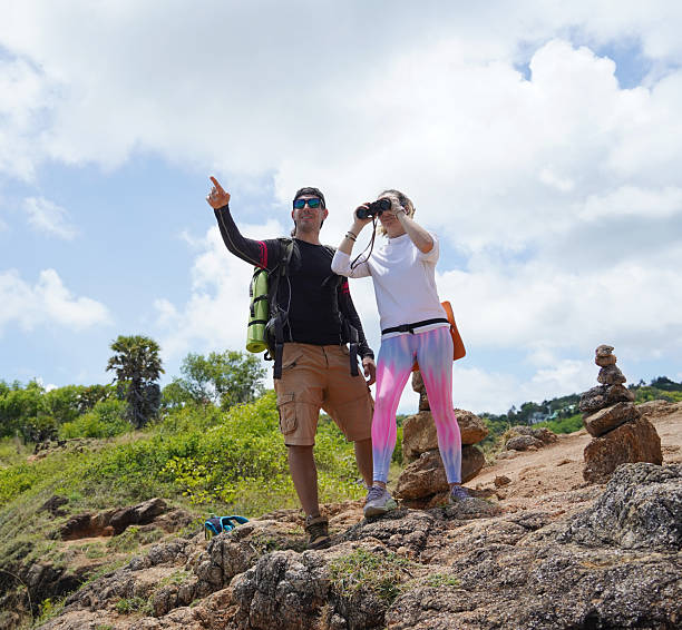 istock A man and a woman are intently looking through binoculars at something interesting in the distance 2214456729