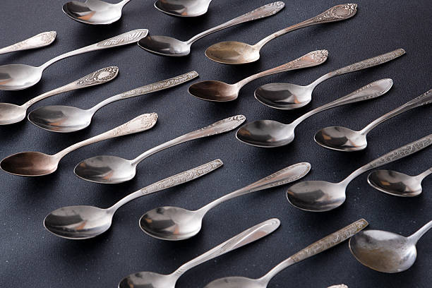 istock Set of different spoons. Silver cutlery on a black background. Spoon on the table 2214458894